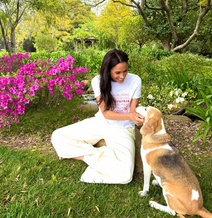 Meghan Markle sitting in a lush garden with her dog, renewing concern for her kids. Meghan Markle sitting in a lush garden with her dog, renewing concern for her kids.