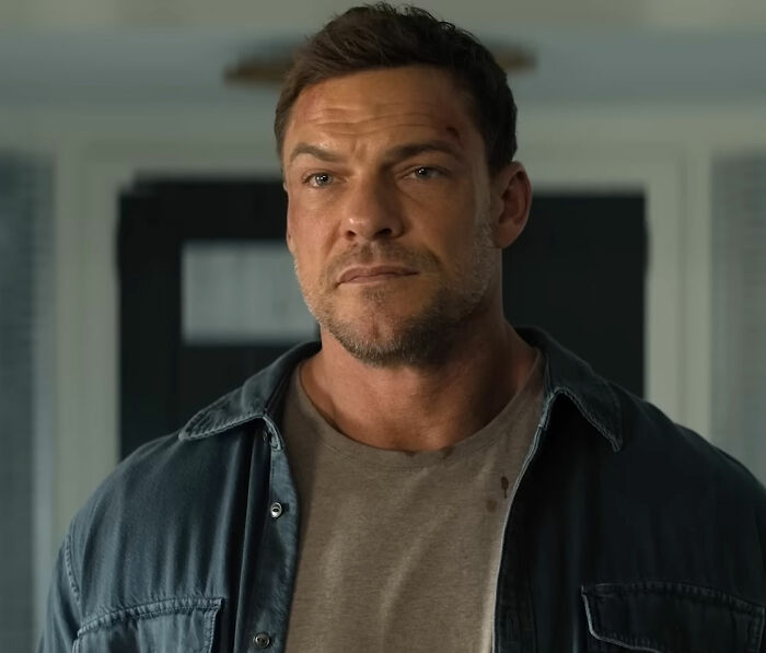 Close-up of Alan Ritchson with a serious expression, showcasing his popular shirtless moment trend. Close-up of Alan Ritchson with a serious expression, showcasing his popular shirtless moment trend.