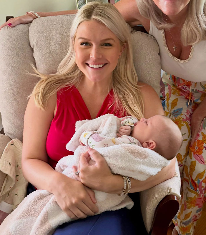 Karoline Leavitt holding her baby, smiling, after returning from maternity leave, facing scrutiny.