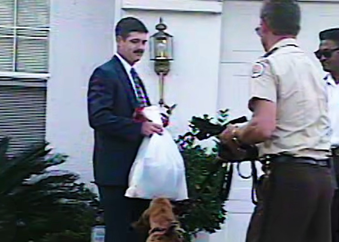 Police officers with a K-9 unit at the house of a serial criminal suspect.