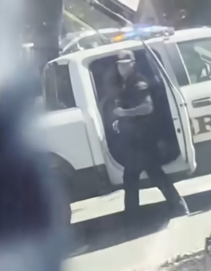 Police officer near a school bus, as furious parents smash their way into the school bus. Police officer near a school bus, as furious parents smash their way into the school bus.
