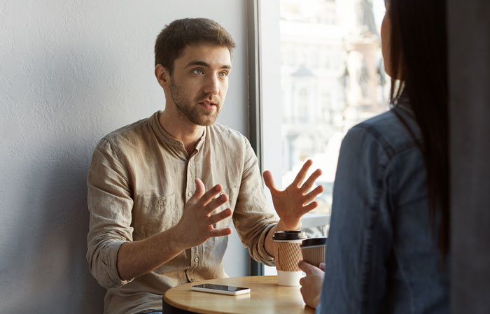 A man talking animatedly to a woman, showing people who forgot names and described things unhinged.