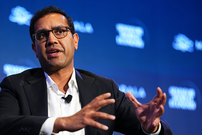 A CEO speaking passionately, gesturing with his hands during an event, discussing losing his job after firing workers.