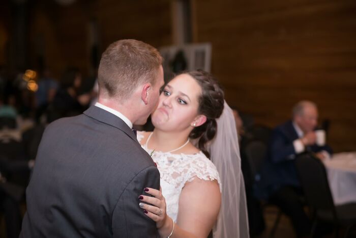 Bride making a funny face while dancing with the groom, a memorable moment among funny wedding photos.