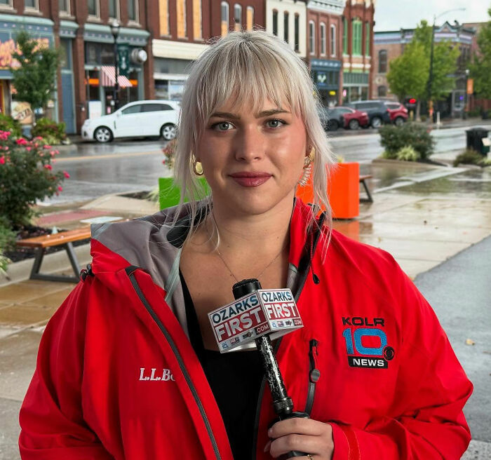 News anchor wearing a red jacket holding a microphone with a KOLR 10 News logo, standing outside, viral news anchor. News anchor wearing a red jacket holding a microphone with a KOLR 10 News logo, standing outside, viral news anchor.