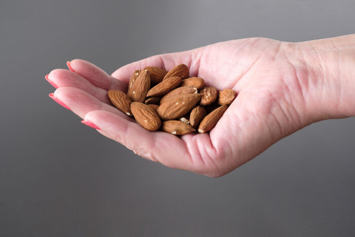 Questionable Instacart shoppers holding a handful of almonds, implying a possible snack choice.