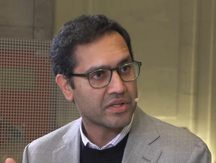 CEO who went viral for firing 900 employees via Zoom, speaking at an event.