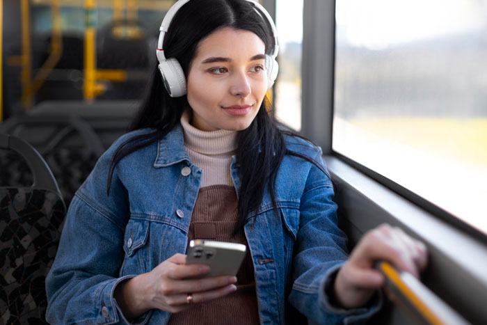 Young woman with headphones on public transportation, practicing safety tips for women. Young woman with headphones on public transportation, practicing safety tips for women.