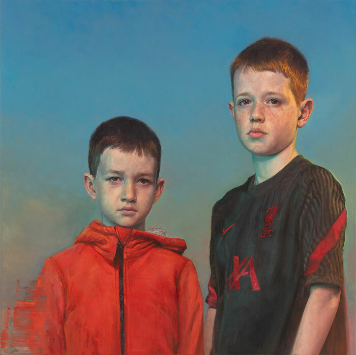 A hyperrealist painting by Ian Cumberland showing two young boys, one in an orange hoodie and one in a dark jersey.