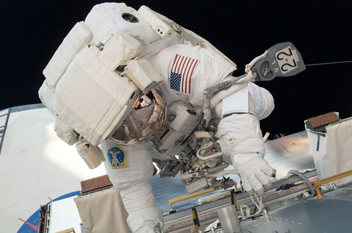 Astronaut in space suit working on a spacecraft, experiencing life on Earth from an unbelievable perspective.