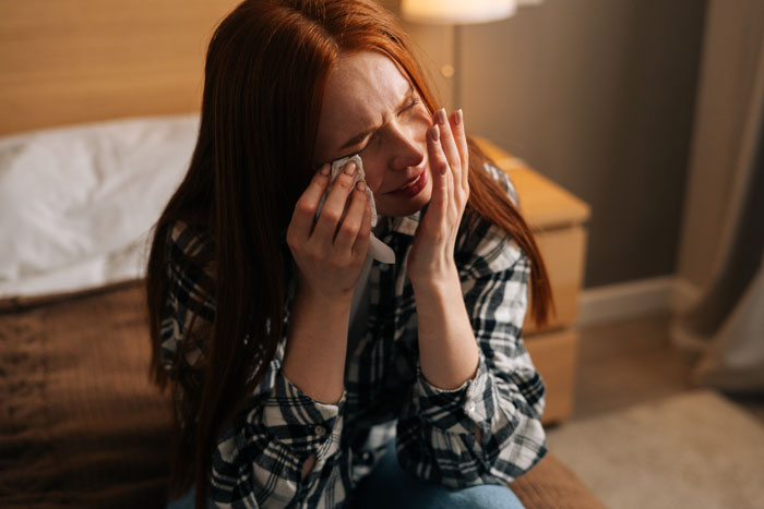 A woman crying, heartbroken by her destroyed home and missing roommate. A woman crying, heartbroken by her destroyed home and missing roommate.
