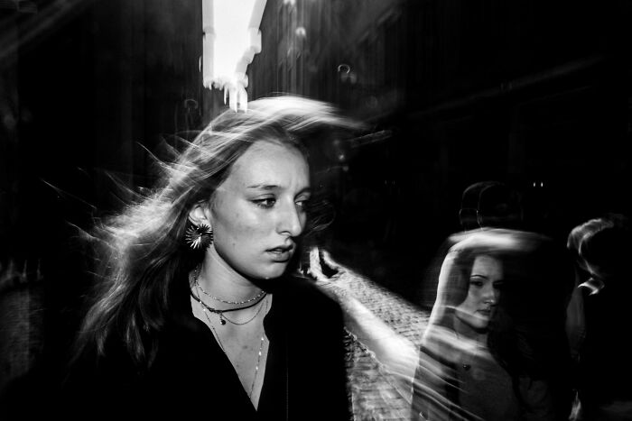 Black and white portrait of a woman with blurred hair, an Edge Street Photography Awards winning image.