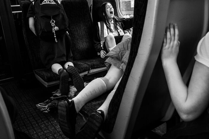 Black and white image of a child yawning on a train, highlighting scenes from the Edge Street Photography Awards.
