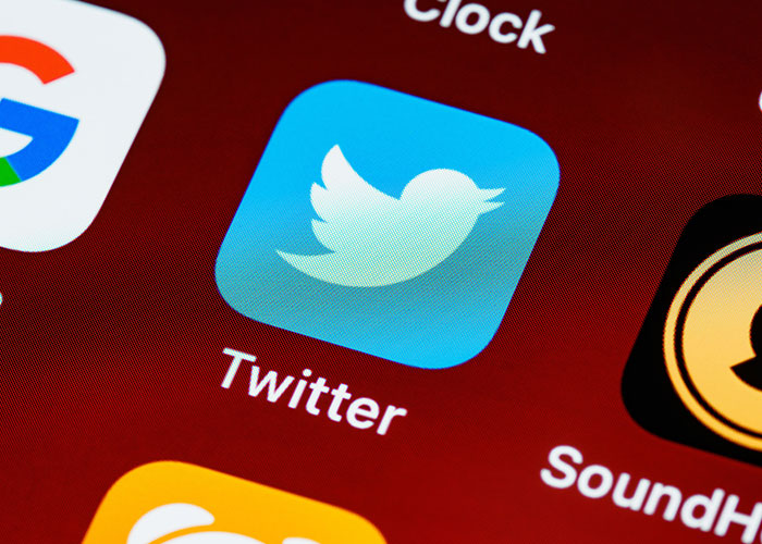 Close-up of the Twitter app icon on a smartphone screen, symbolizing sharing stories about worst first dates.