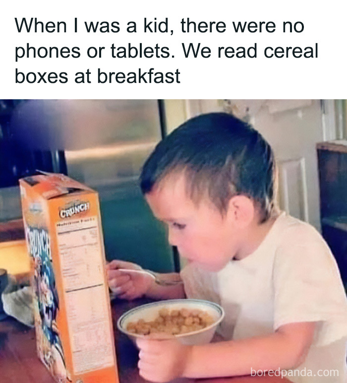 A young boy eating cereal and reading the back of a cereal box, a common Gen X childhood experience.