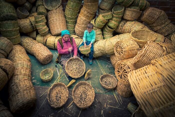 Murat Bakmaz captures the beauty of everyday life, showing a woman and child weaving baskets amidst a pile of finished work.