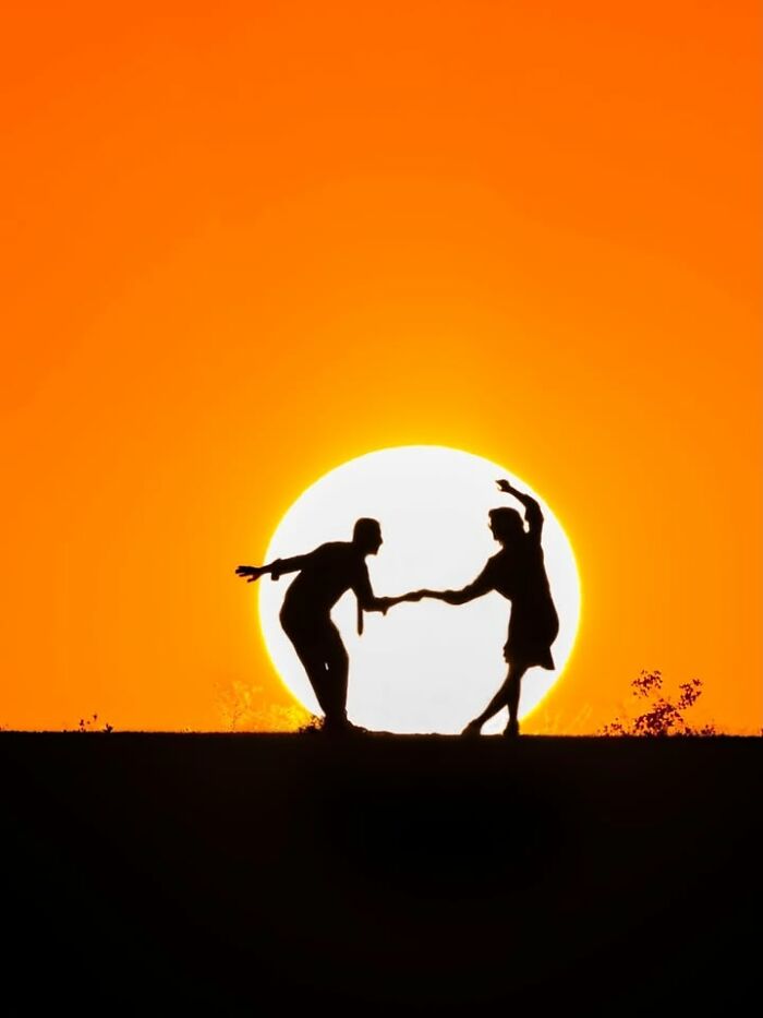Murat Bakmaz captures the beauty of everyday life: A silhouette of a couple dancing against a vibrant orange sunset.