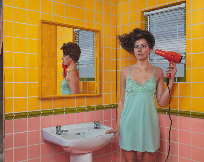 Hyperrealist paintings by Ian Cumberland: a woman drying her hair in a yellow tiled bathroom.