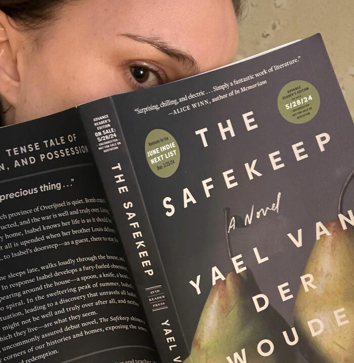 A person holding The Safekeep book, relating to Natalie Portman's diva reputation and potential unflattering portrayals.