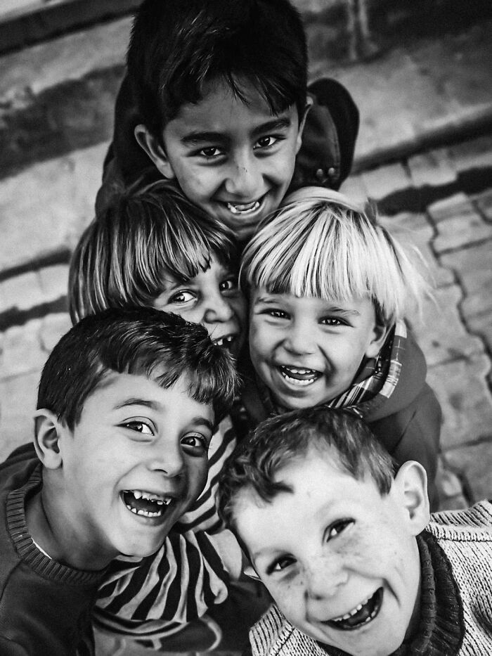 A perfectly timed street photo by Mehmet Bayram captures a group of five smiling children, turning an everyday moment into art.