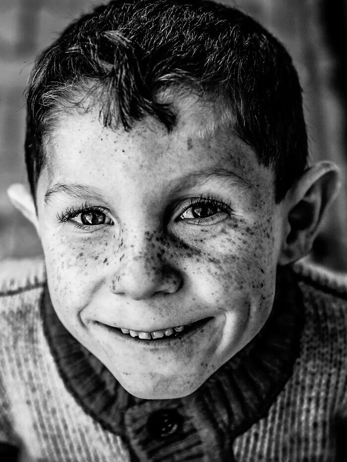 A perfectly timed street photo by Mehmet Bayram captures a smiling boy with freckles, making an everyday moment into art.