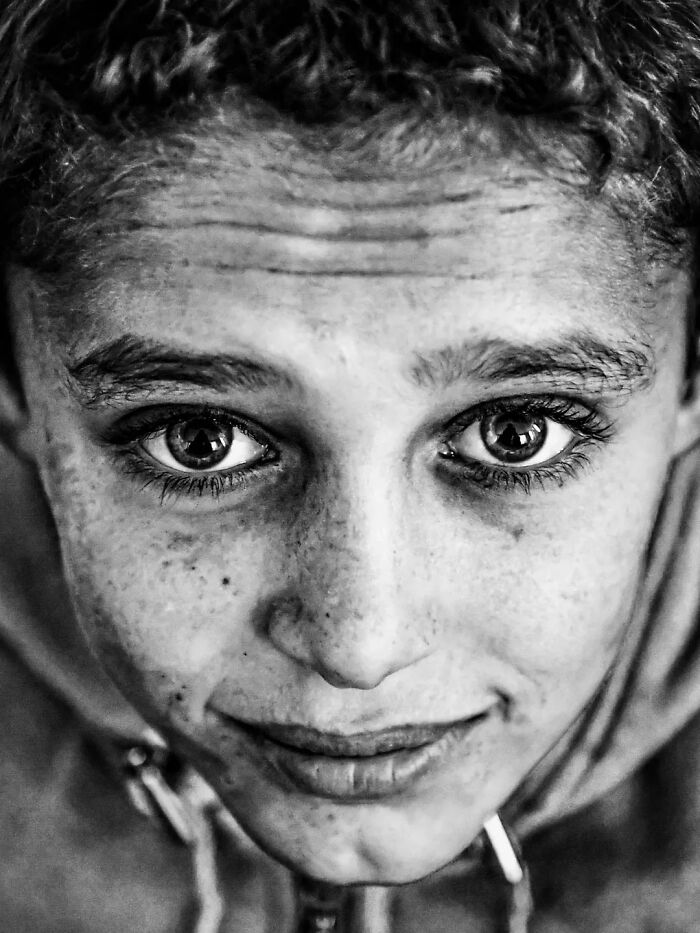 A perfectly timed street photo by Mehmet Bayram shows a boy's face with intense eyes, turning an everyday moment into art.