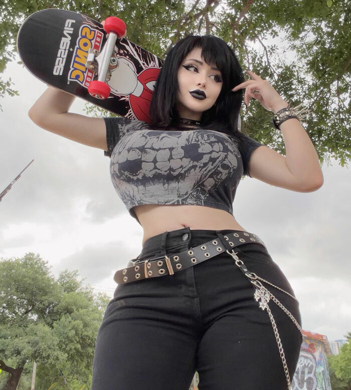 Goth baddie with black hair and makeup, holding a skateboard, showcasing her transformation. Goth baddie with black hair and makeup, holding a skateboard, showcasing her transformation.