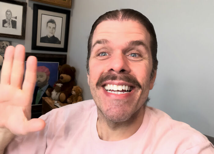 Perez Hilton smiling and waving, livestreaming from his hospital bed after a horrifying incident. Perez Hilton smiling and waving, livestreaming from his hospital bed after a horrifying incident.