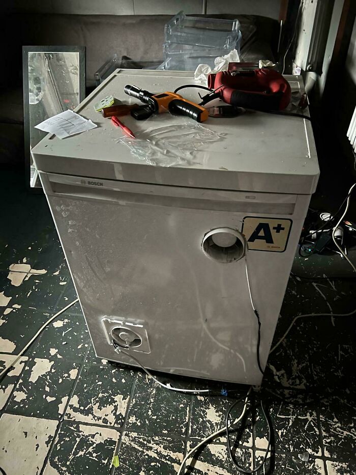 A white Bosch appliance with tools on top and a ventilation hole, showing clever solutions from random junk.