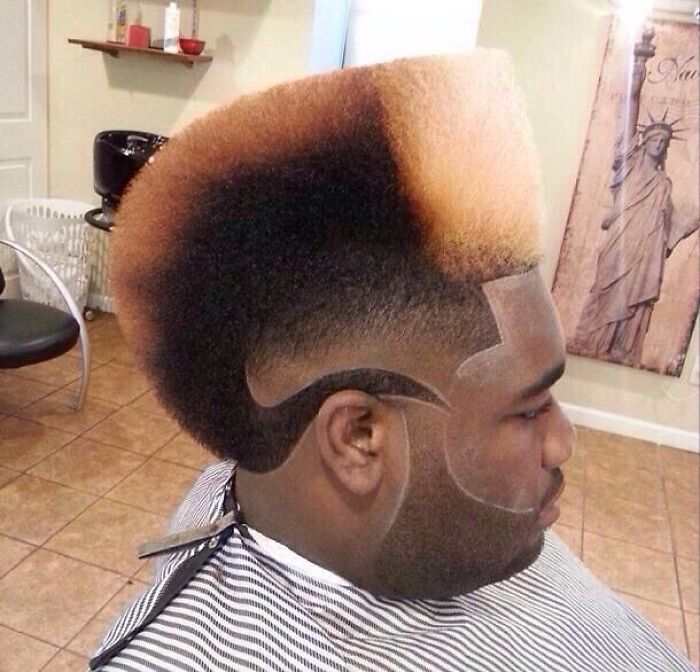 A man with a bold hairstyle featuring a high fade and intricate shaved designs on the side of his head.