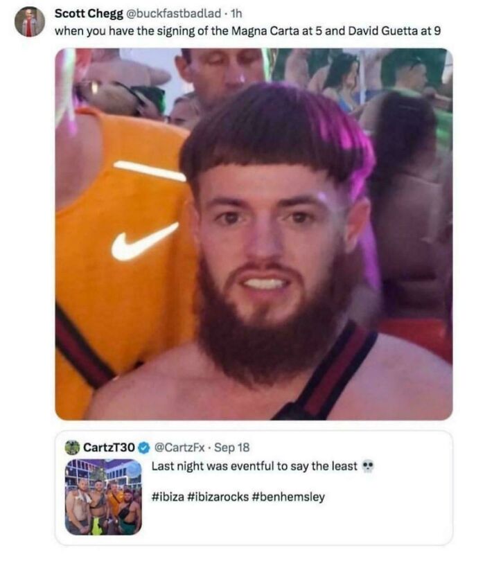 A man with a distinct bowl-cut hairstyle and a full beard, looking directly at the camera in a crowded setting, showcasing bold hairstyles.