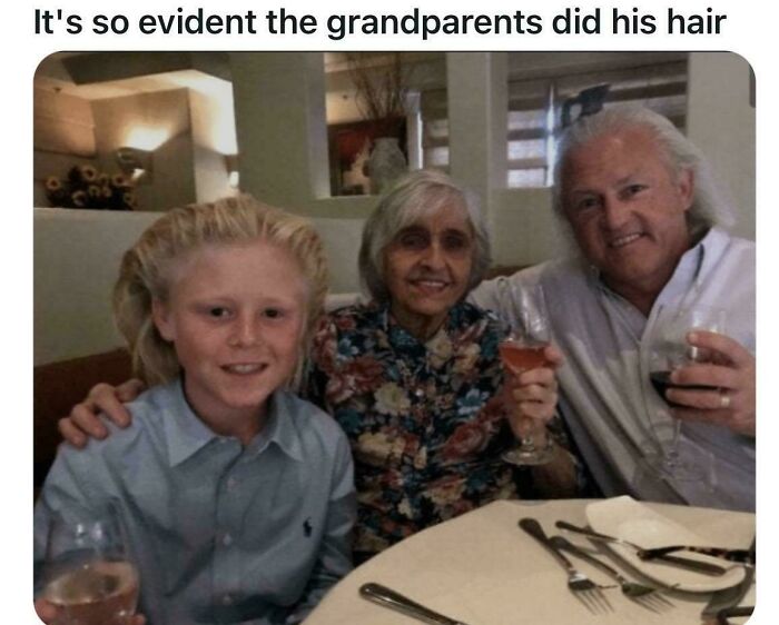 A young boy with an unusually styled, spiky blonde haircut, sitting between two older adults who are holding drinks, displaying bold hairstyles.