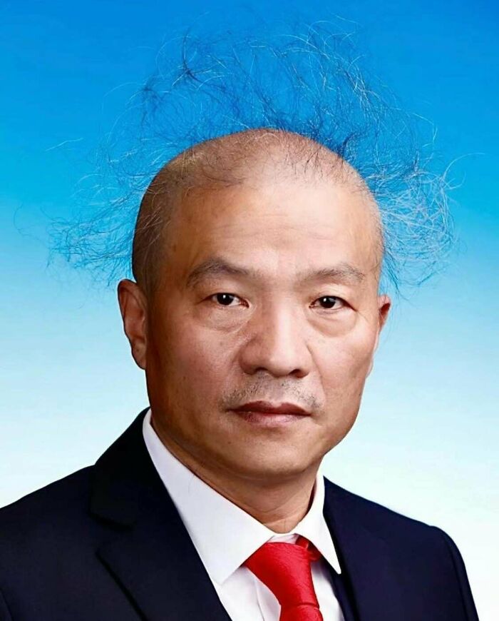 A man with sparse, wild hair standing up in an unusual, bold hairstyle.