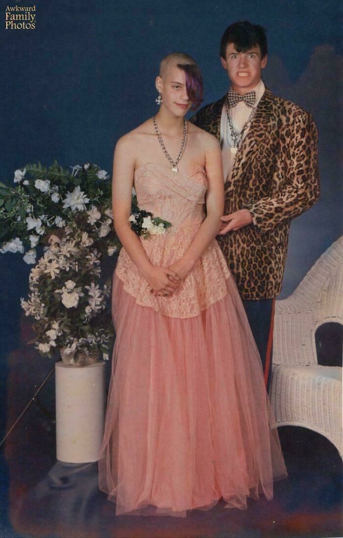 A couple in bold hairstyles and outfits for a prom photo.