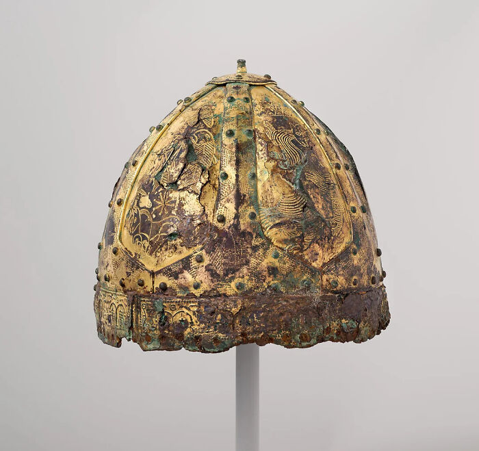 Ancient, gilded helmet with intricate designs, representing artifacts from the Middle Ages.