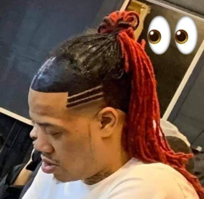 Man with red dreadlocks tied up, shaved sides with lines, and an expressive bold hairstyle.