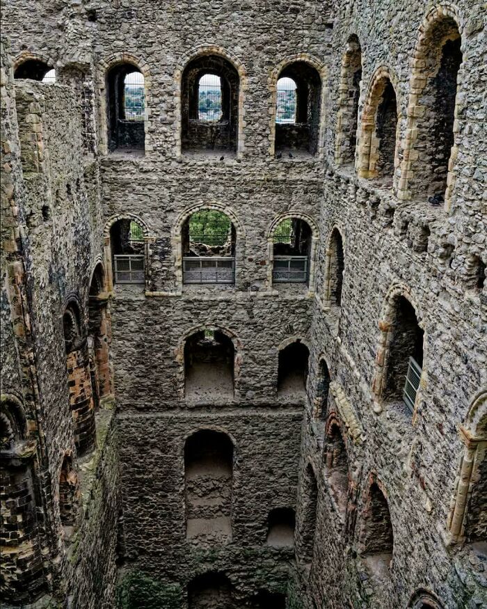The ruins of a stone castle showing multiple arched windows and doorways from the Middle Ages.
