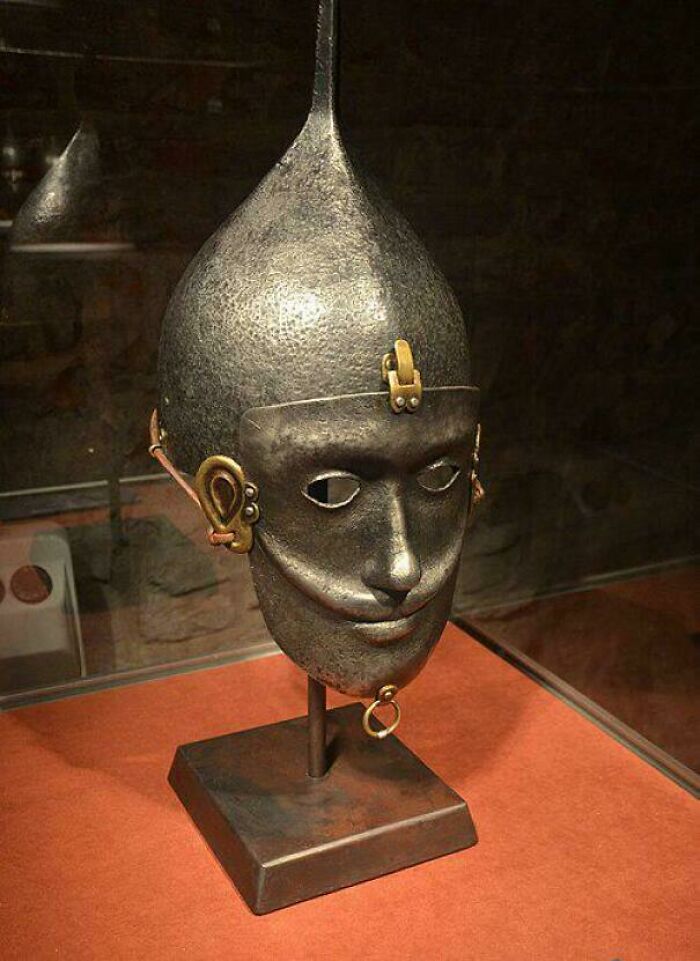 An ornate metal helmet with a face mask, an intriguing artifact from the Middle Ages' human history.