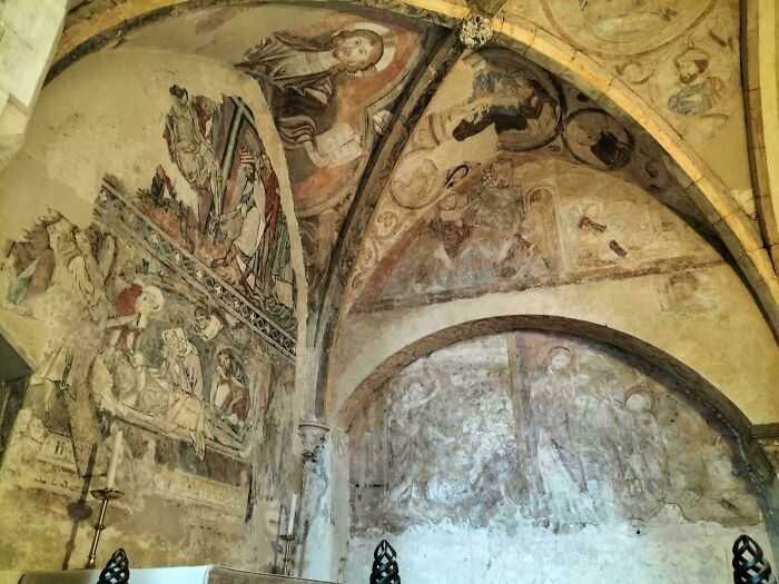 Ancient frescoes on a vaulted ceiling, illustrating the fascinating human history of the Middle Ages.