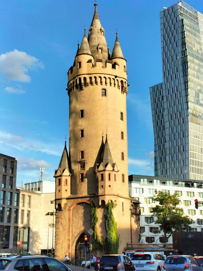 A medieval tower with spires under a blue sky, showcasing human history from the Middle Ages.