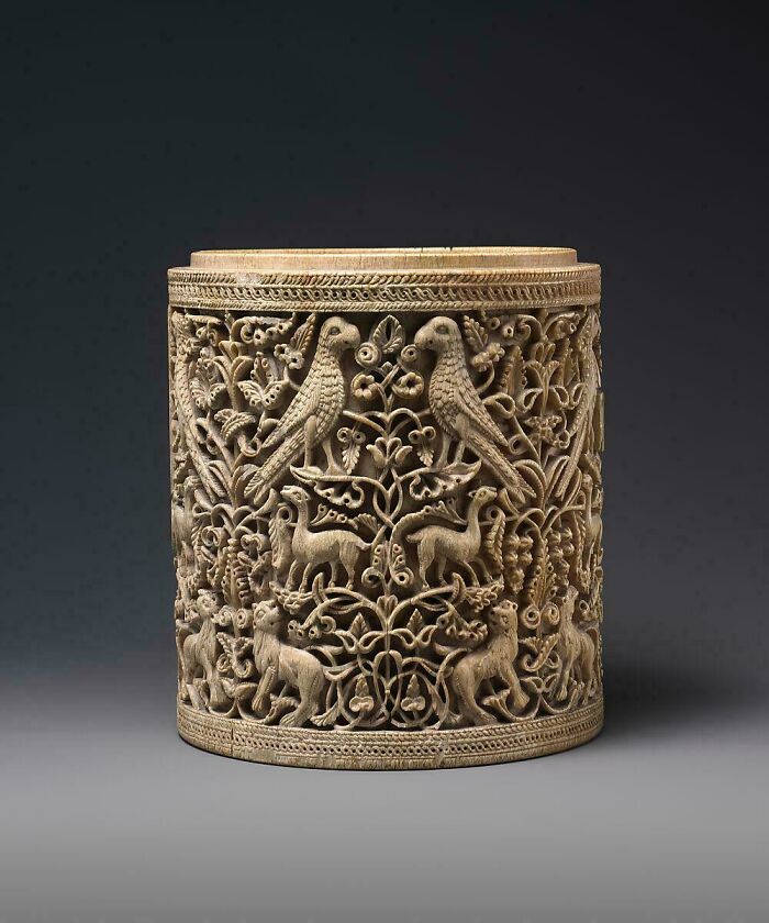 Intricate carved cylindrical box showcasing animals and foliage, a fascinating piece of the Middle Ages.