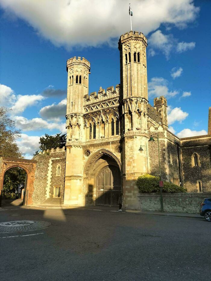 A grand stone gatehouse with two towers under a blue sky, a powerful symbol of the Middle Ages.