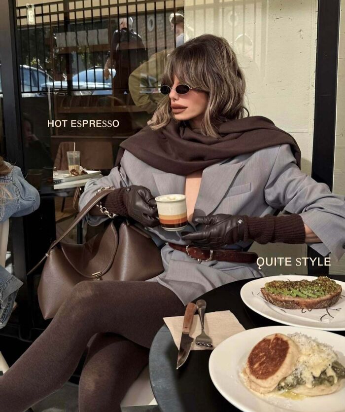 A woman on social media posing with a cup of espresso, looking quite unnatural in her pose at a cafe.