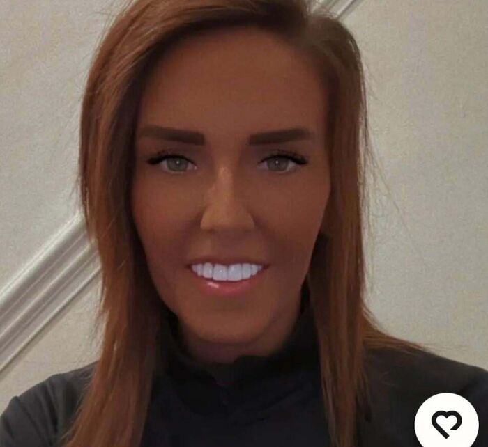 A woman with heavily bronzed skin, bright eyes, and white teeth, not looking natural on social media.