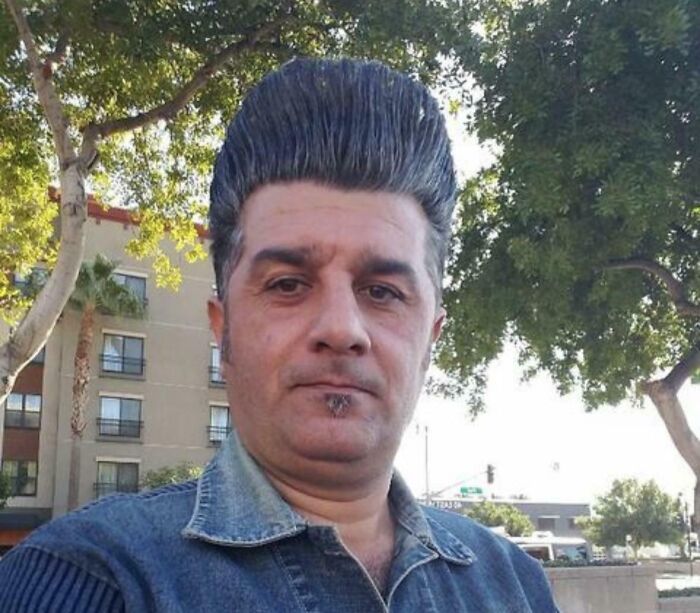 A man with an exaggerated pompadour, showcasing bold hairstyles.
