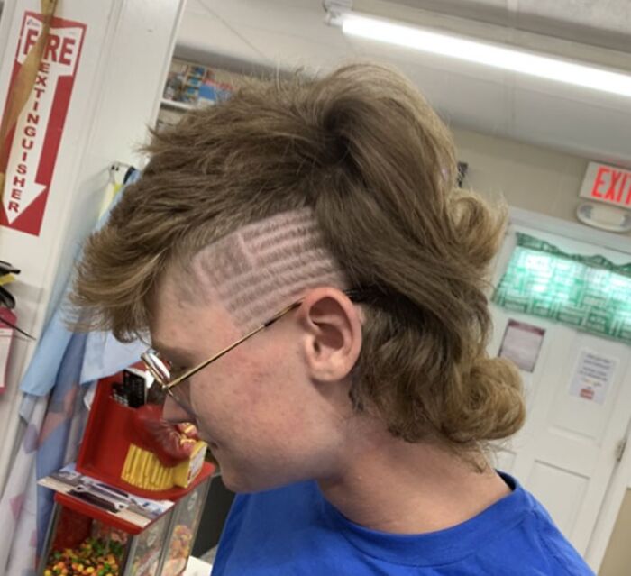 A bold hairstyle featuring a mullet cut with a shaved design on the side.