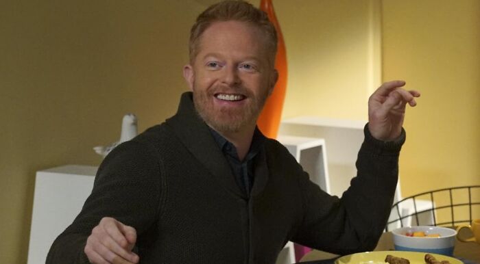 Jesse Tyler Ferguson as Mitchell Pritchett from Modern Family, smiling at a table, discussing his character's profession.