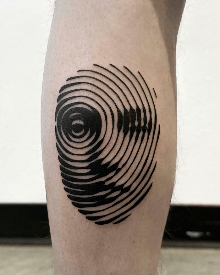 A leg displaying a stunning abstract circular tattoo, creating an optical illusion with multiple rings.