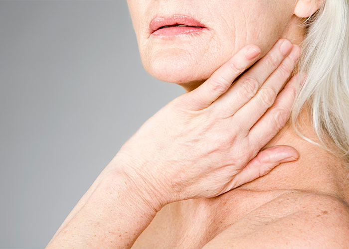 Close-up of a woman's neck and chest, showing skin changes, a hidden perimenopause symptom.