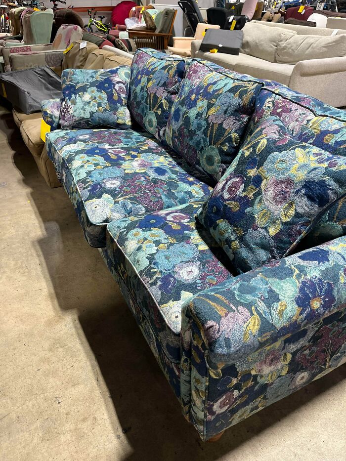 Floral pattern couch in shades of blue and purple, a stylish thrift store jackpot furniture piece.